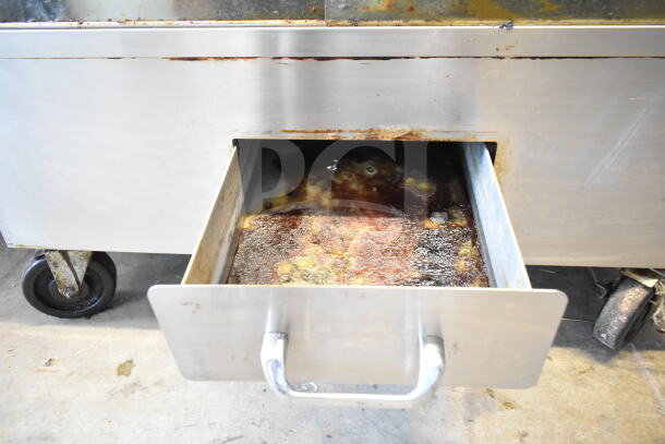 Attias commercial rotisserie oven with visible drip tray and commercial casters. Natural gas powered, 70,000 BTU.