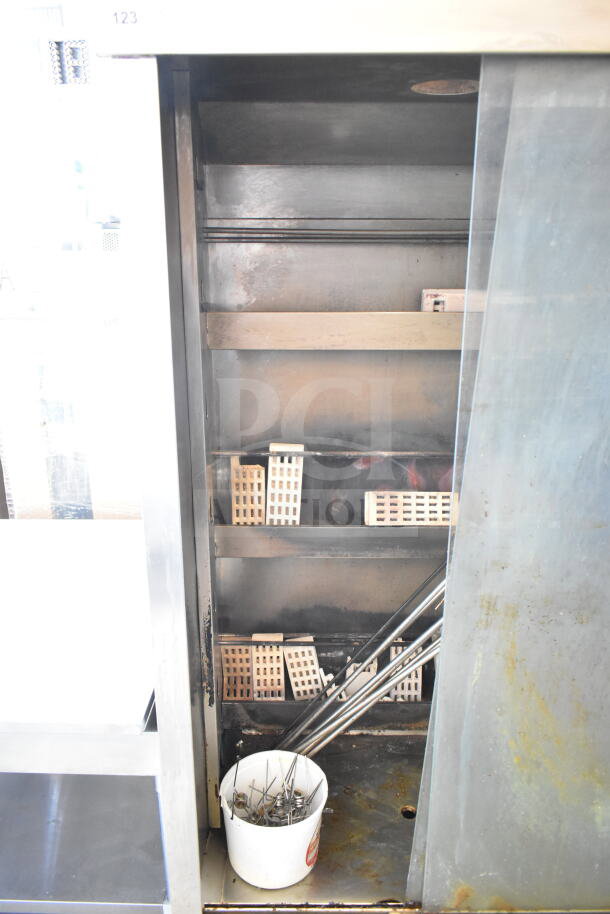 Attias commercial natural gas rotisserie oven, 70,000 BTU, on casters. Interior shelves and skewers shown. Used condition.