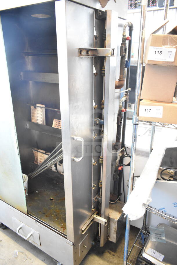 Attias commercial natural gas-powered rotisserie oven, 70,000 BTU, on casters. Stainless steel, visible wear, open door.