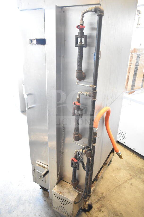 Attias commercial natural gas rotisserie oven on casters, 70,000 BTU. Features visible gas pipes and orange hose.
