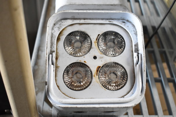Leoch battery with two Rockville lights. Shows four round bulbs, slight rust and wear on white casing.