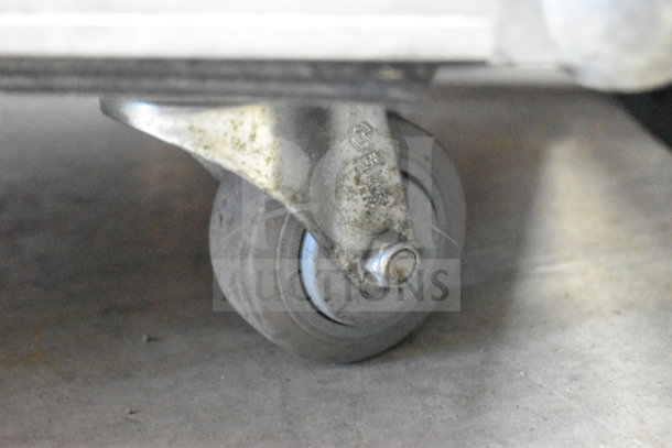 Rockville hard case wheel close-up, showing metal caster in used condition. Ideal for transporting lighting equipment.