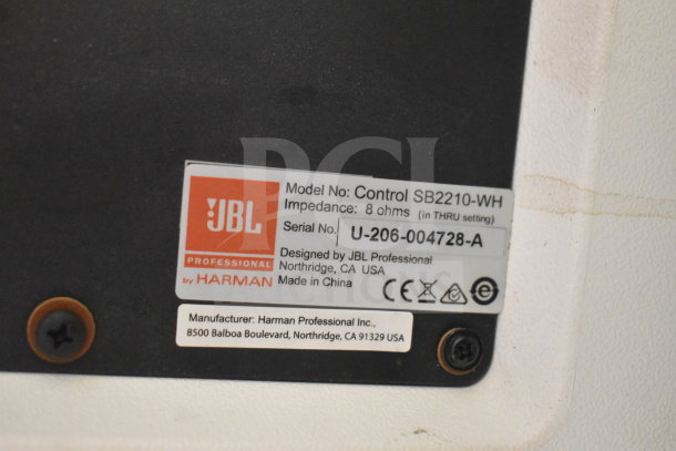 JBL Control SB2210-WH speaker label showing model, impedance of 8 ohms, and serial number U-206-004728-A.
