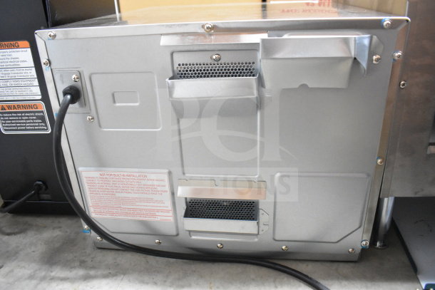 Panasonic NE-17523 countertop commercial microwave oven, rear view, showing power cord and warning labels, in good condition.