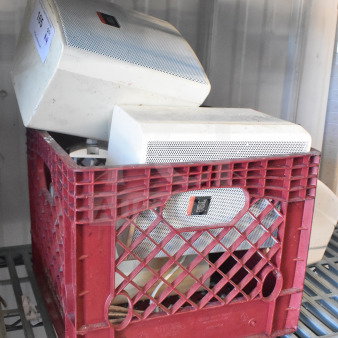 Four JBL Control 25AV speakers in a red crate, some wear visible. Ideal for audio installations.