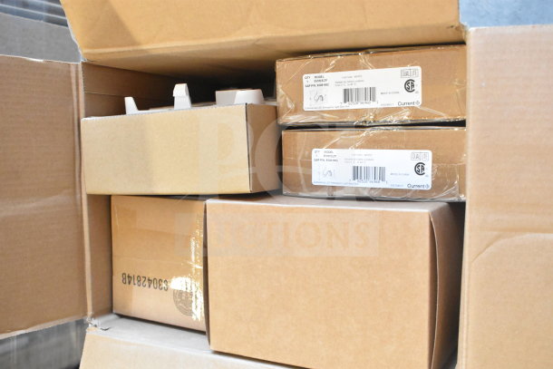 Box of various items including Dual Lite EVHCEZP emergency light back box and Dual Lite double remote head, new in packaging.