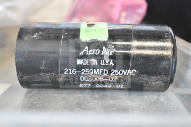Black Aero M capacitor labeled "216-259MFD 250VAC" with signs of wear, made in USA. Part of auction lot with Vizio subwoofer.