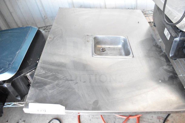 Steel panel with a recessed square compartment, slightly worn surface. Suitable for industrial use or repair projects.