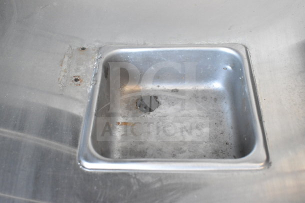 Stainless steel panel with a small square inset and visible signs of wear. Ideal for industrial or restoration use.
