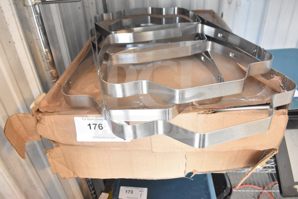 Stainless steel folding chafer frames on a cardboard box. Includes 5 baking pans. Condition: used. Auction label visible.