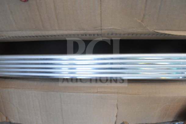 Two stainless steel baking pans stacked in an open cardboard box. Visible edges and grooves, appear new.