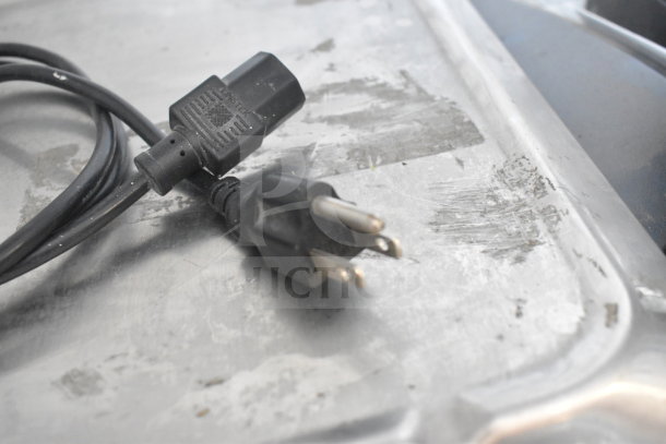 Power cord of the 2024 Hobart HTi-7LH4W Commercial Scale on a metal surface, showing plug detail.