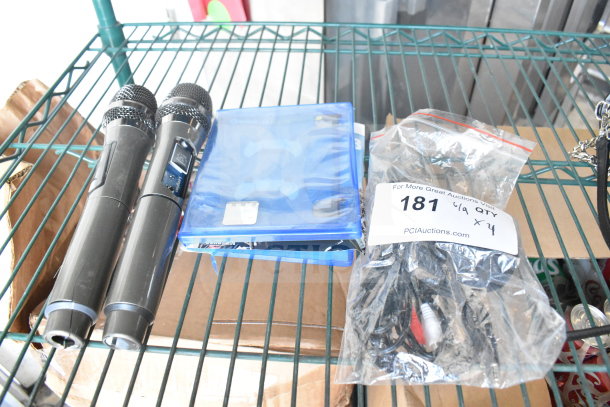 Two black microphones, a PS5 Madden 23 game case, and a sealed bag of cables on a metal shelf.