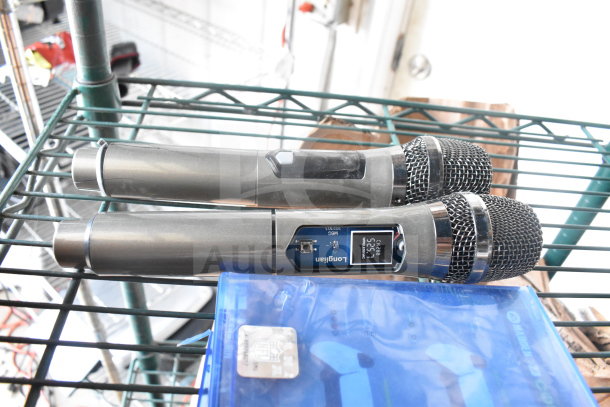 Two Longjian wireless microphones and PS5 Madden 23 game case, in good condition, on a metal shelf.