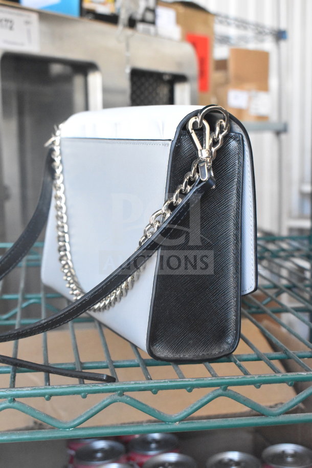 Kate Spade New York white purse with black strap, silver chain detail, excellent condition.