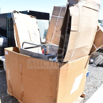 Large cardboard box containing 10 new scratch and dent items, including a pan rack and wire shelves, on a wooden pallet.