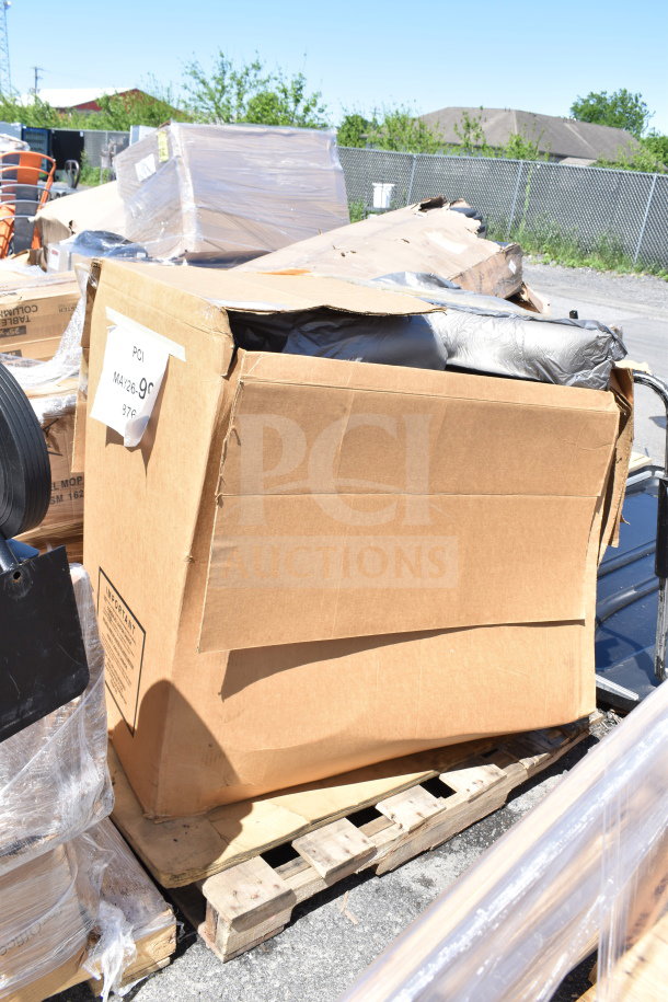 Cardboard box on pallet, partially open, showing black wrapped contents. Label reads "MAY26-99, 500 lb. Capacity."