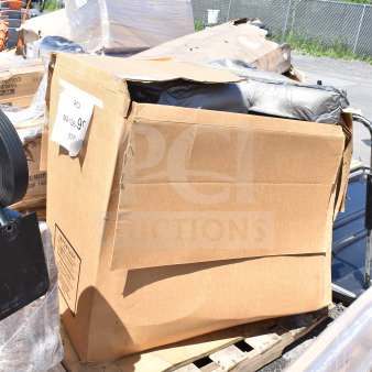 Cardboard box on pallet, partially open, showing black wrapped contents. Label reads "MAY26-99, 500 lb. Capacity."