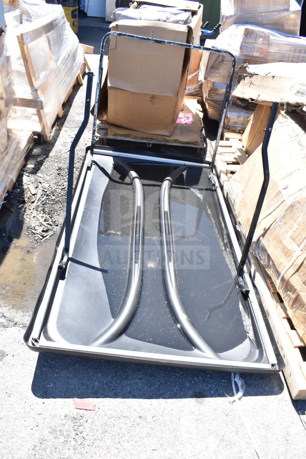 Brand new black unit with minor scratches and dents, frame structure visible, surrounded by boxed pallets, ready for use.