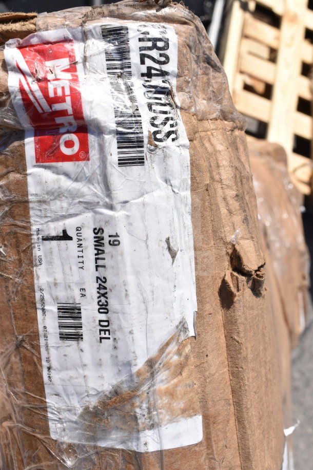 Brown package with METRO label showing "SMALL 24X30 DEL." New scratch and dent items including cart, wall shelf.
