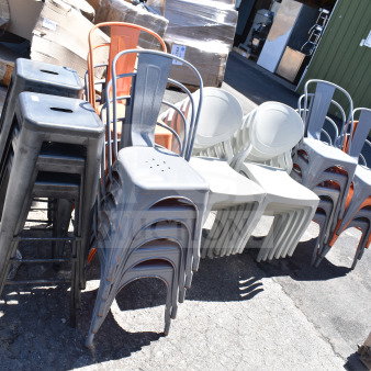 Brand new scratch and dent items: gray and orange Tolix style chairs, bar stools, white patio chairs, outdoors.