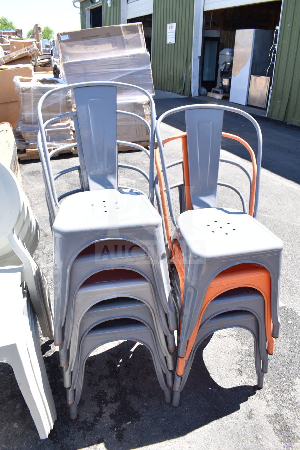 Stack of new gray and orange Tolix-style chairs with some scratch and dent items, including bar stools and white patio chairs.