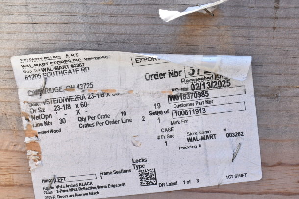 Label on wooden surface showing order details for 10 Vista Arched Black doors, 23-1/8 x 60 inches, shipped to Walmart #3262.