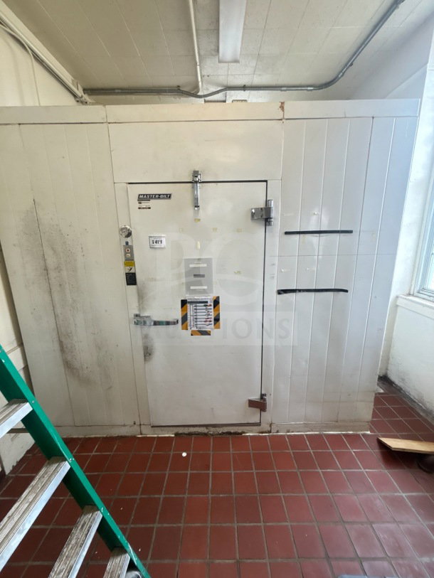 Master-Bilt 8'x12' walk-in box with compressor, evaporator fan, and visible door markings. Some signs of wear.