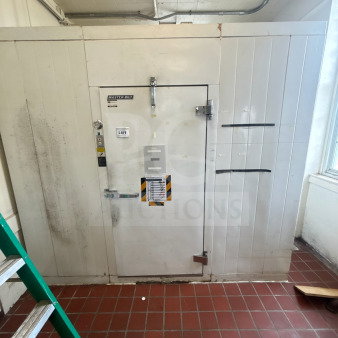 Master-Bilt 8'x12' walk-in box with compressor, evaporator fan, and visible door markings. Some signs of wear.