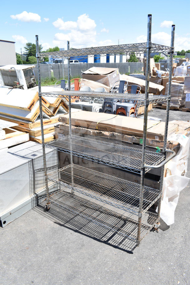 Chrome finish 5-tier wire shelving unit with casters, one missing. Buyer must dismantle. Consider freight charges.