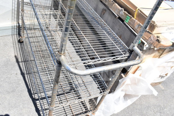 Chrome finish 5-tier wire shelving unit on casters, missing one caster. Buyer must dismantle.