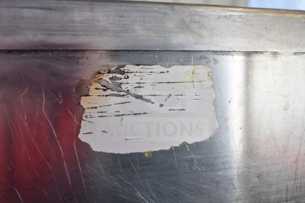 Commercial countertop gas-powered deep fat fryer with visible surface wear and a partially removed label.