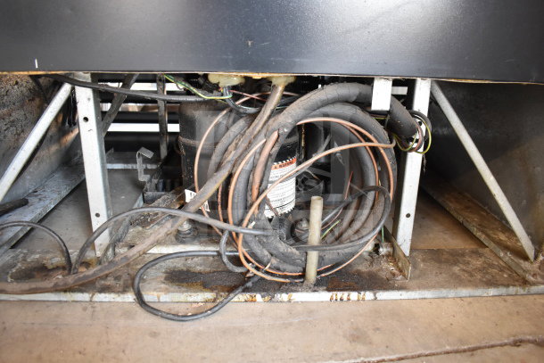 Beverage Air 2-door commercial cooler engine space with visible wiring and components; condition appears worn.