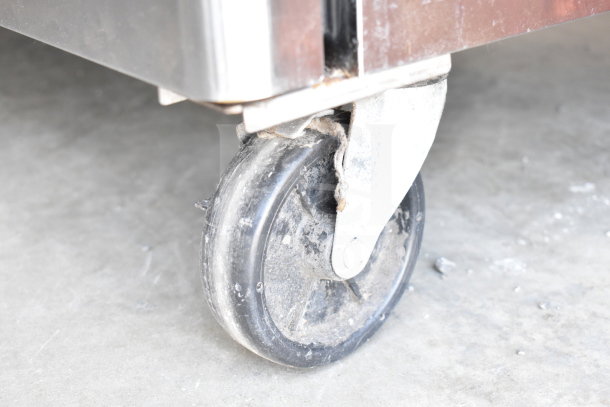 Turbo Air TST-72SD-30 prep table caster wheel, showing moderate wear, part of a commercial sandwich salad unit.