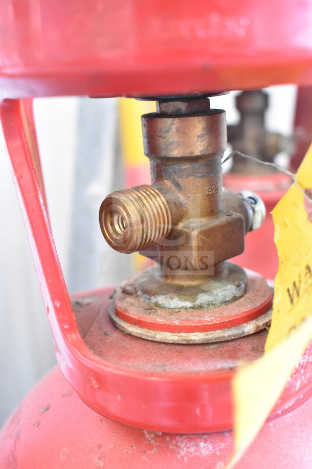 Red CO2 tank valve with visible brass fittings. Features wear and tear. Note: Pickup only, no shipping available.