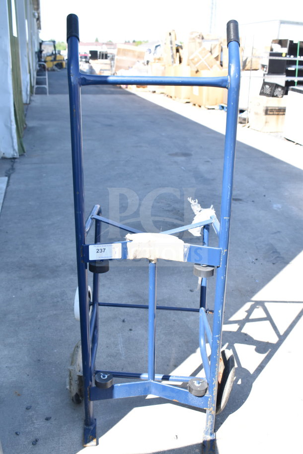 Blue furniture dolly with handles and wheels, showing moderate wear. Tag marked "237" attached on frame.