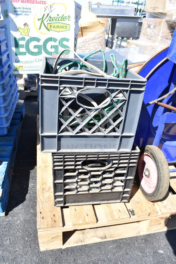 Pallet lot with crates, banding cords, and various items including a Kreider Farms egg box, stacked on wooden pallets.