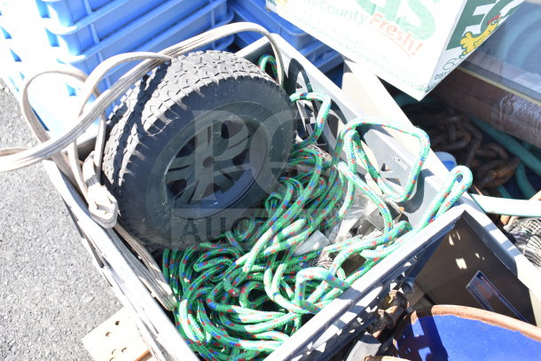 Pallet lot containing rugged tire, multicolored cords, and metal banding station. Items appear used.