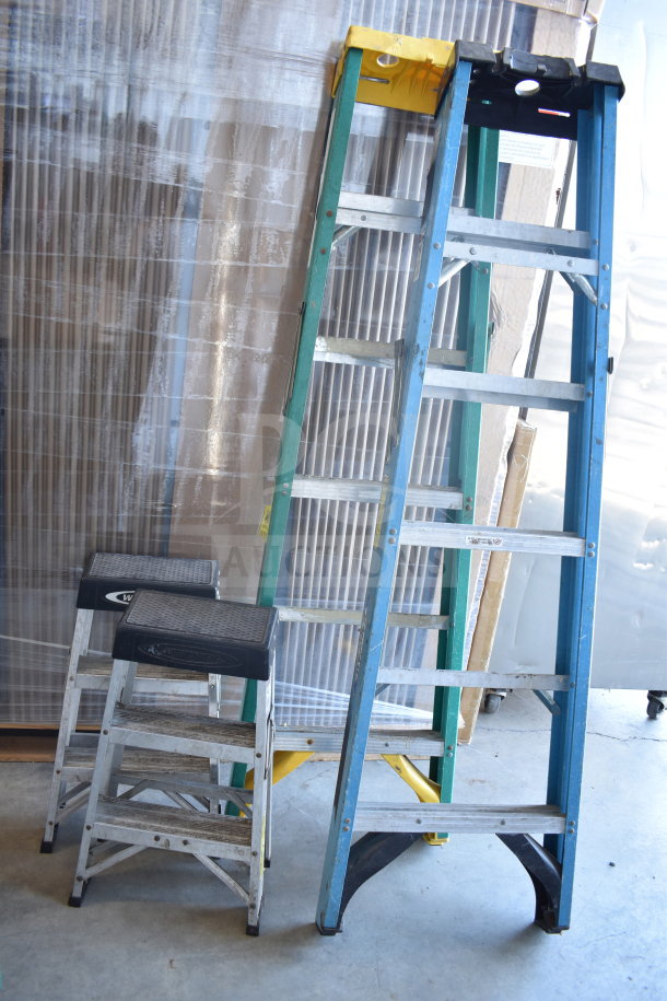 Four various ladders, including step stools and extension ladders, in used condition. Mixed colors and types.