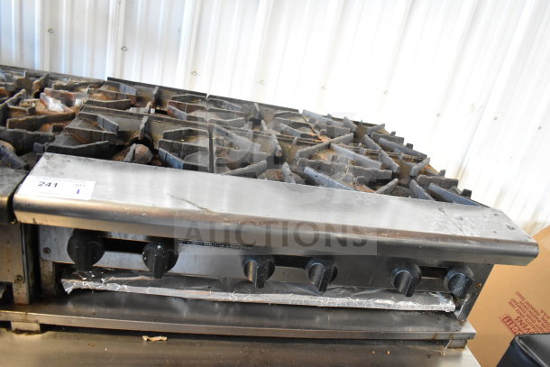 American Range commercial gas-powered 6-burner range. Stainless steel, used condition, with visible controls and knobs.