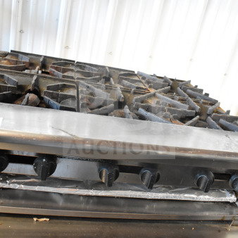 American Range commercial gas-powered 6-burner range. Stainless steel, used condition, with visible controls and knobs.