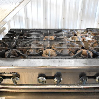 Radiance Commercial 6 Burner Gas Range, countertop model, used condition, visible wear; features robust metal knobs.