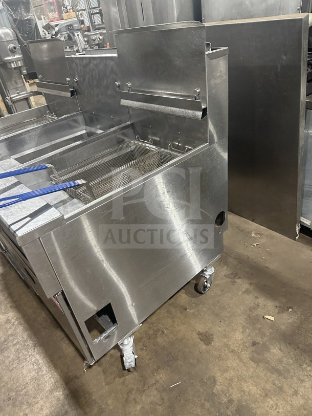 Pitco Solstice Supreme Series SSH75 commercial triple bay fryer, stainless steel, natural gas, with backsplash and basket fryer on casters.