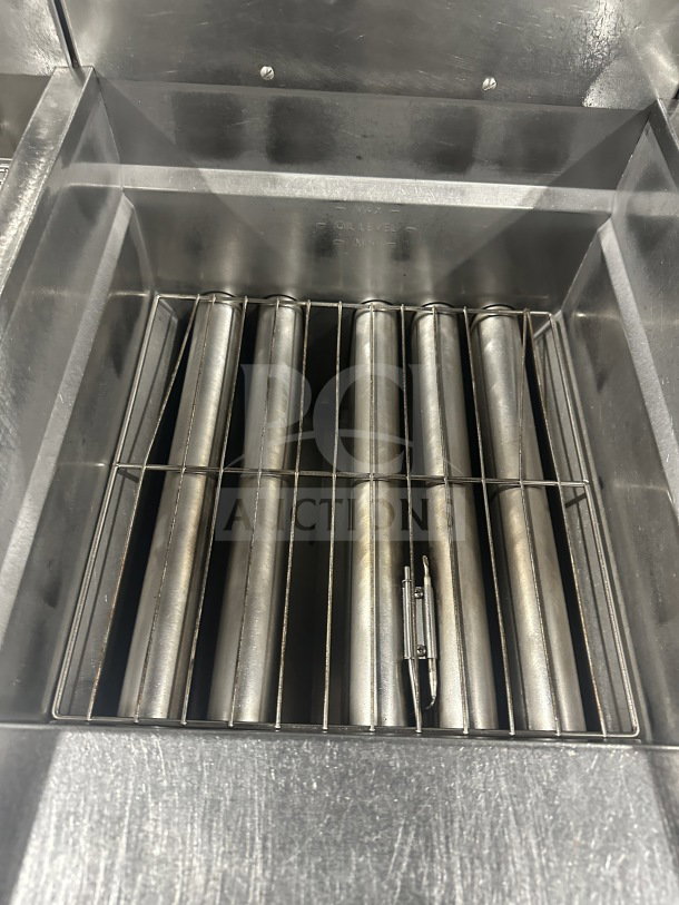 Pitco Solstice SSH75 stainless steel triple bay natural gas fryer, interior view showing heating elements and oil level markings.