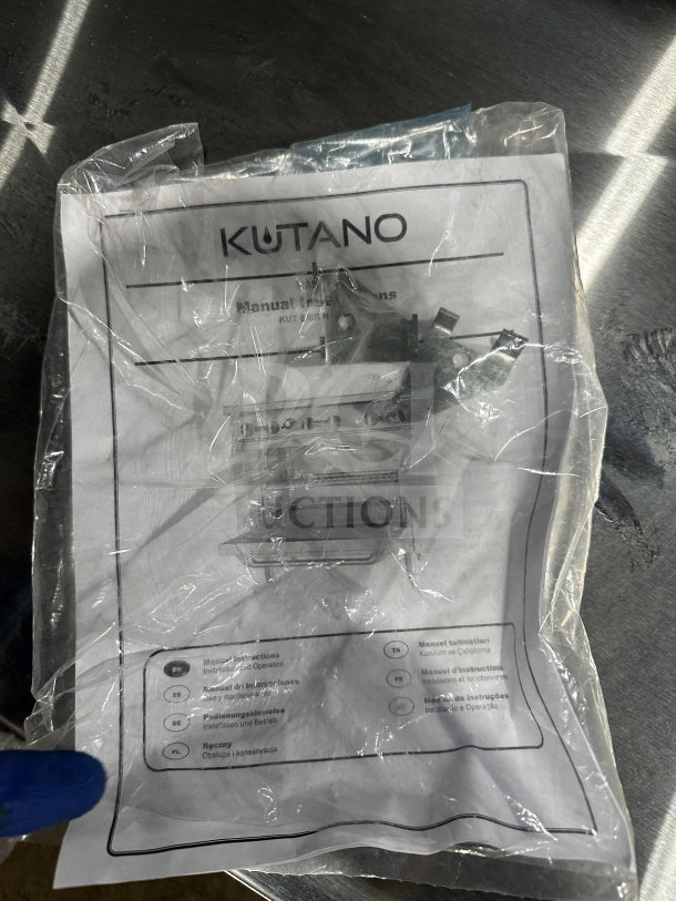 Plastic-wrapped Kutano manual for KUT6BRN36N6 model range/oven. Multiple languages listed, slightly crumpled package.