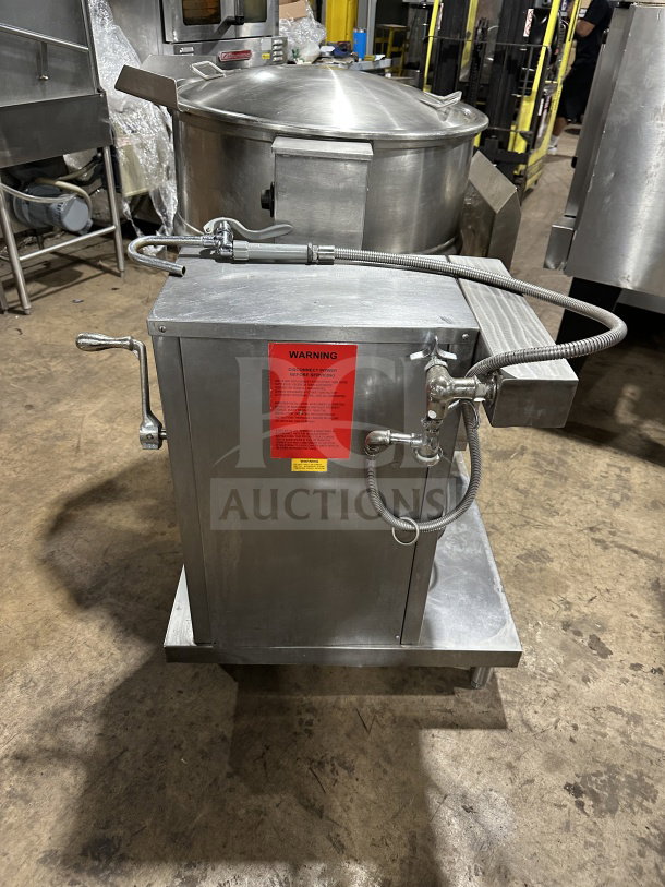 Groen DH140 Commercial Stainless Steel 40 Gal. Tilting Steam Kettle, Natural Gas, 120V, 1 Phase, on legs, with red warning label.