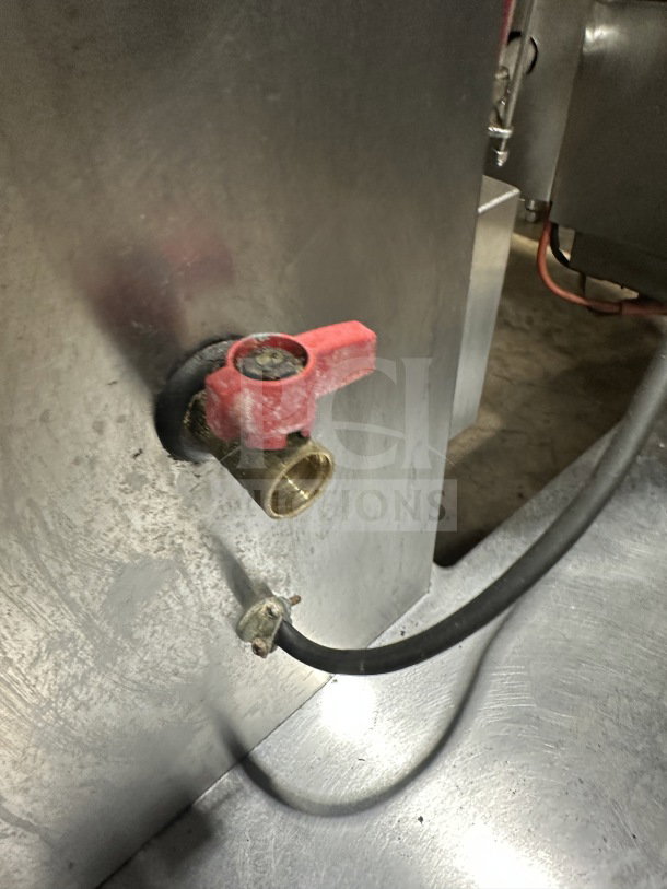 Groen DH/1-40 stainless steel 40-gal tilting steam kettle, natural gas-powered, 120V, 1 phase, on legs, with red valve.