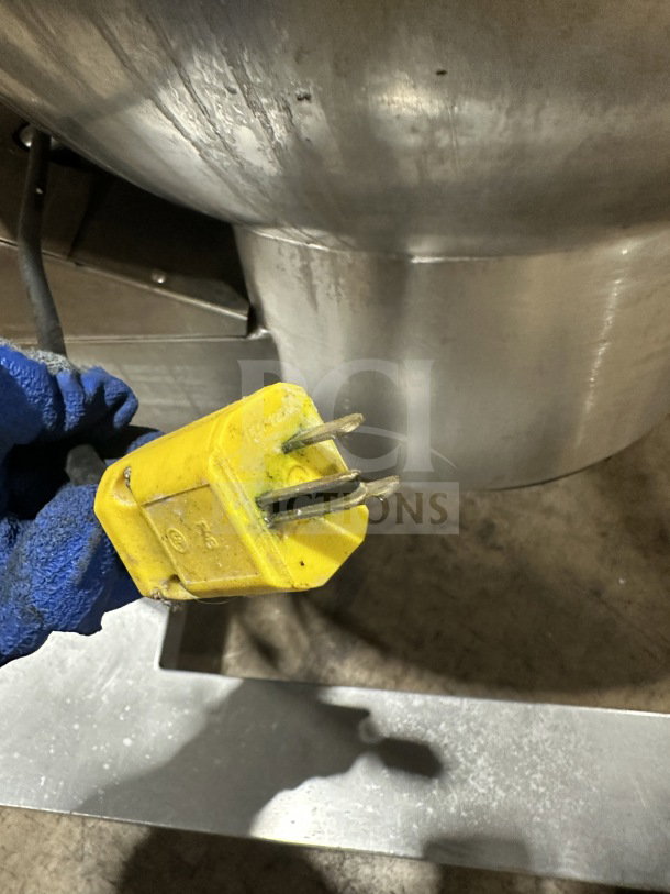 Groen DH/1-40 stainless steel tilting steam kettle, 40 gal, natural gas, 120V, 1 phase, shown with yellow plug, on legs.