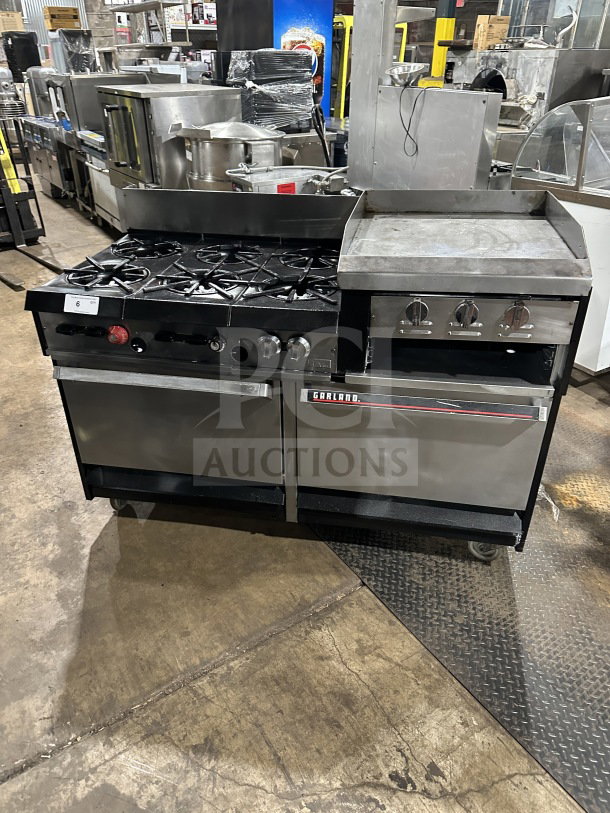 Garland commercial stainless steel gas range with 6 burners, raised griddle, double oven, broiler, backsplash, and casters.