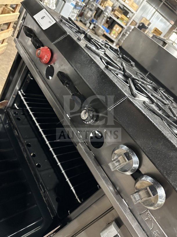 Garland stainless steel 6-burner range with griddle, double oven, broiler, salamander shelf, and casters, in used condition.